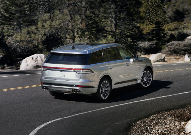 A 2023 Lincoln Aviator® Grand Touring model is shown being driven on a tight turn of a mountain road | McKie Lincoln, Inc. in Rapid City SD